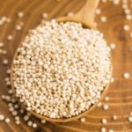 White quinoa seeds on a wooden background