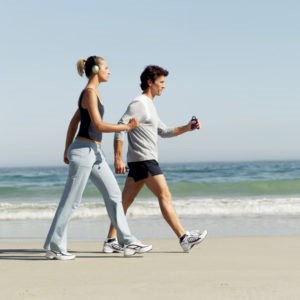 side view of a couple walking on the beach