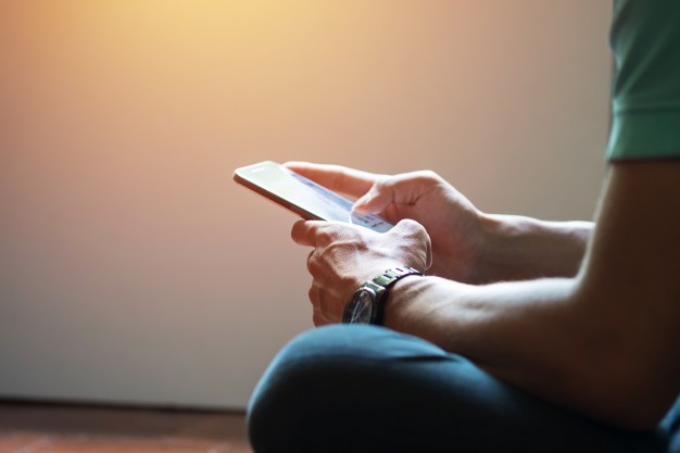 hipster-using-a-touch-screen-smart-phone-hands-close-up-vintage-colors_1423-91