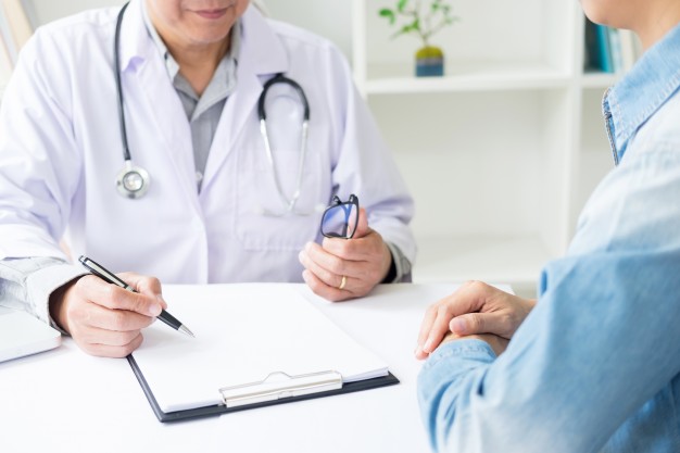 patient-listening-intently-to-a-male-doctor-explaining-patient-symptoms-or-asking-a-question-as-they-discuss-paperwork-together-in-a-consultation_1423-1367